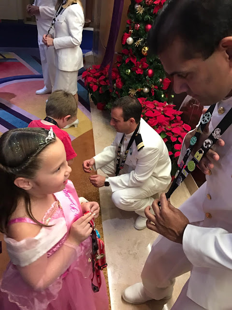 A girl trading pins with a Disney Cruise line cast member